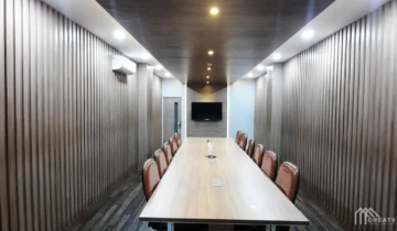 Desain interior ruang rapat besar minimalis dengan wall panel kisi-kisi kayu kustom dan meja meeting panjang oleh kontraktor interior