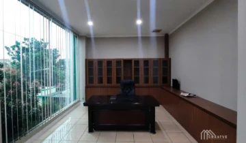 Desain interior ruang kerja manager eksekutif dengan meja direktur kustom dan lemari file besar bermotif kayu di samping jendela kaca