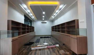 Hasil renovasi area pameran produk dengan lemari rak display kustom berlapis HPL TACO urat kayu dan plafon drop ceiling